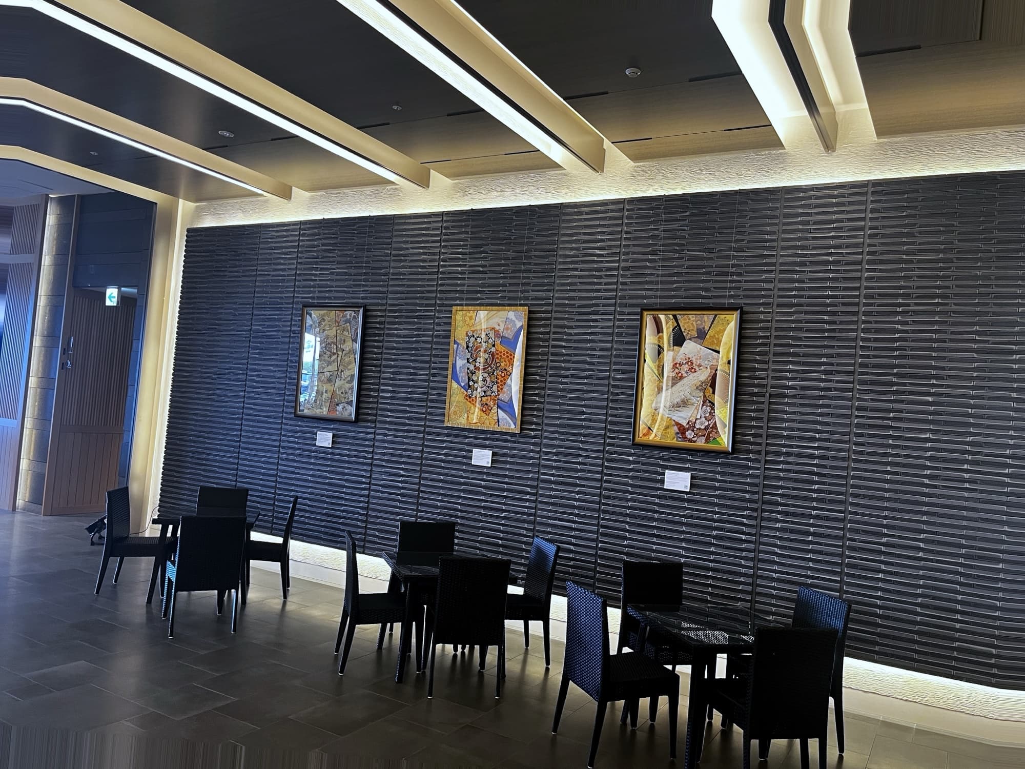 The lounge wall: three large works, each with its own caption plate