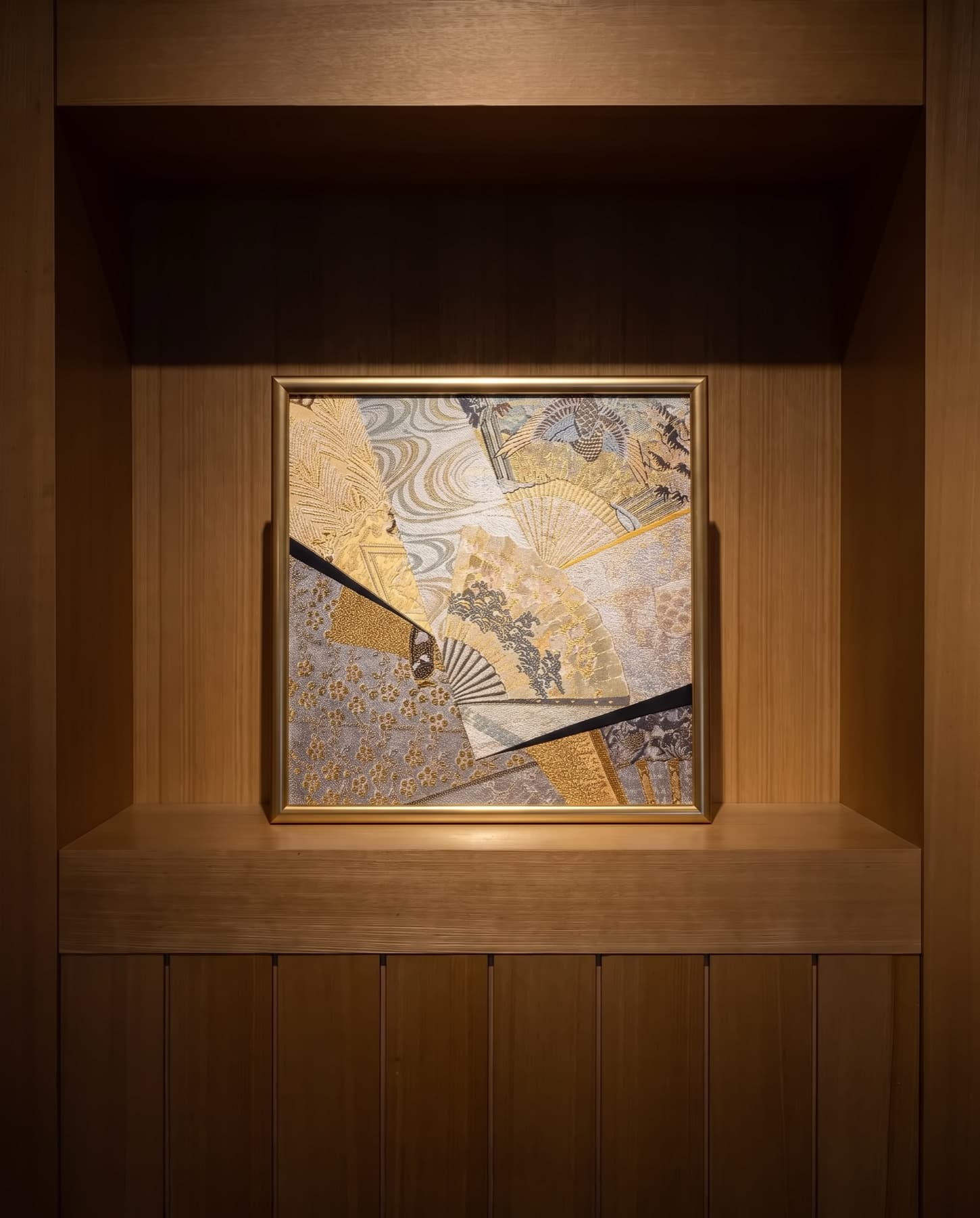 A single piece in a lit niche, the gold thread catching the light